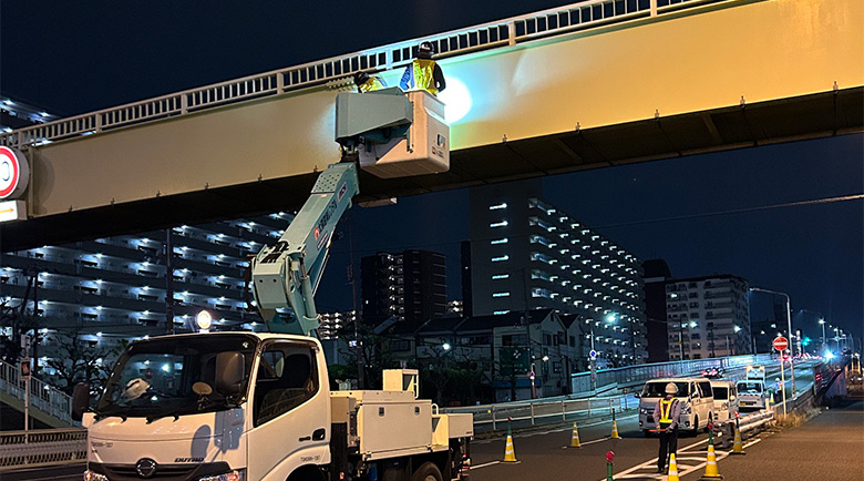 高所作業車に乗り夜間施工を行う作業員