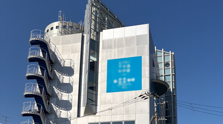 建物壁面に水平に美しく施工されたネーミングライツシートの遠景