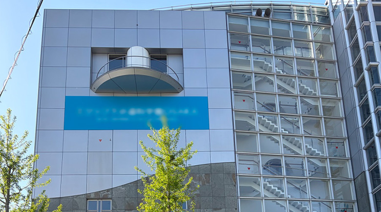 正面から見た建物壁面に水平に美しく施工されたネーミングライツシート