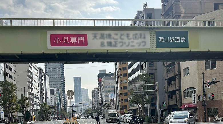 交通量の多い道路にかかる歩道橋に施工されたシート、正面遠景