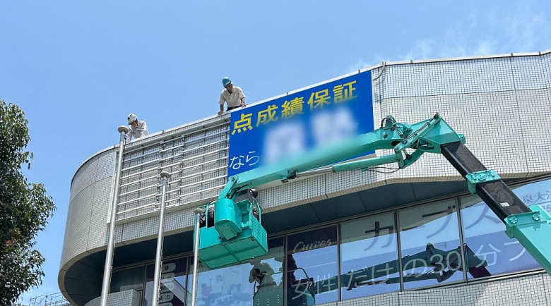 LED電飾看板の設置作業を上から見守る作業員