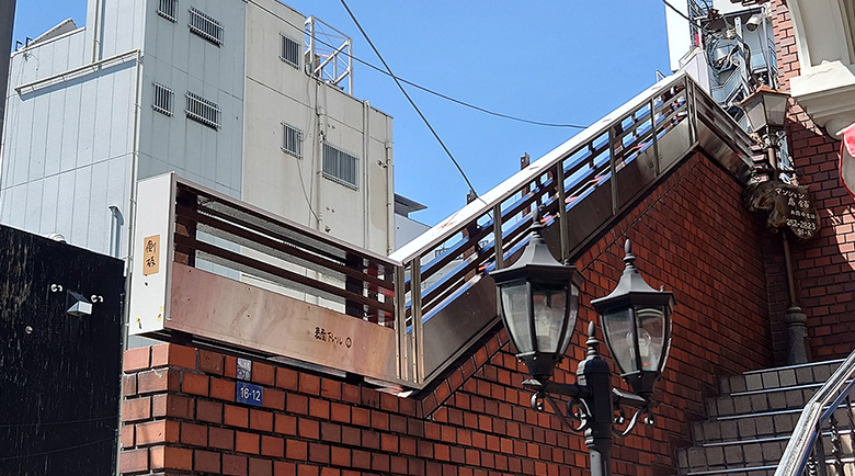 経年劣化した建物外階段手摺のメンテナンス風景、内側からの視点で