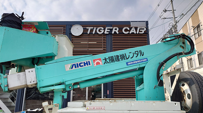 社名サイン施工前外観下からの目線で